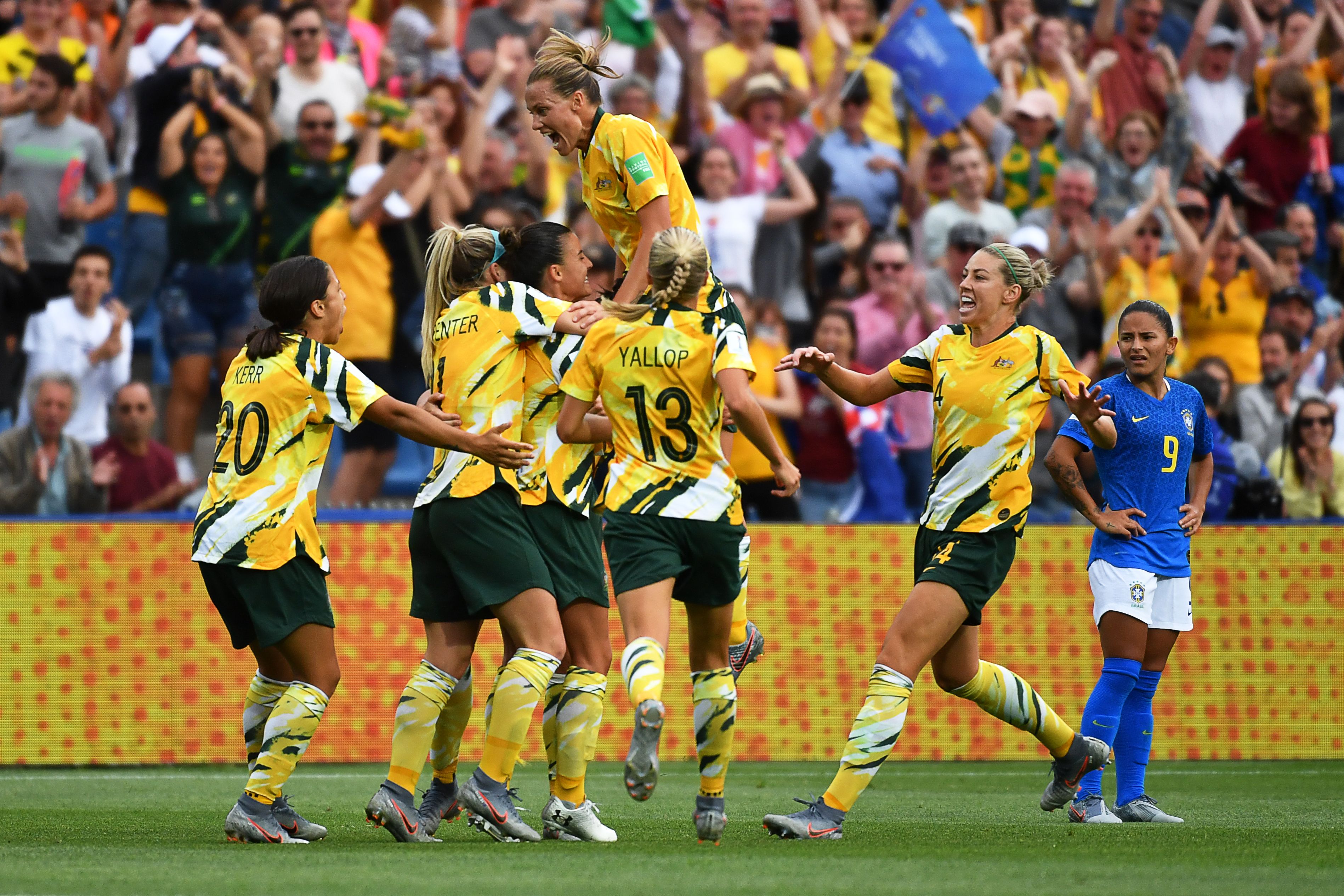 A photo of Matildas football players running to celebrate together
