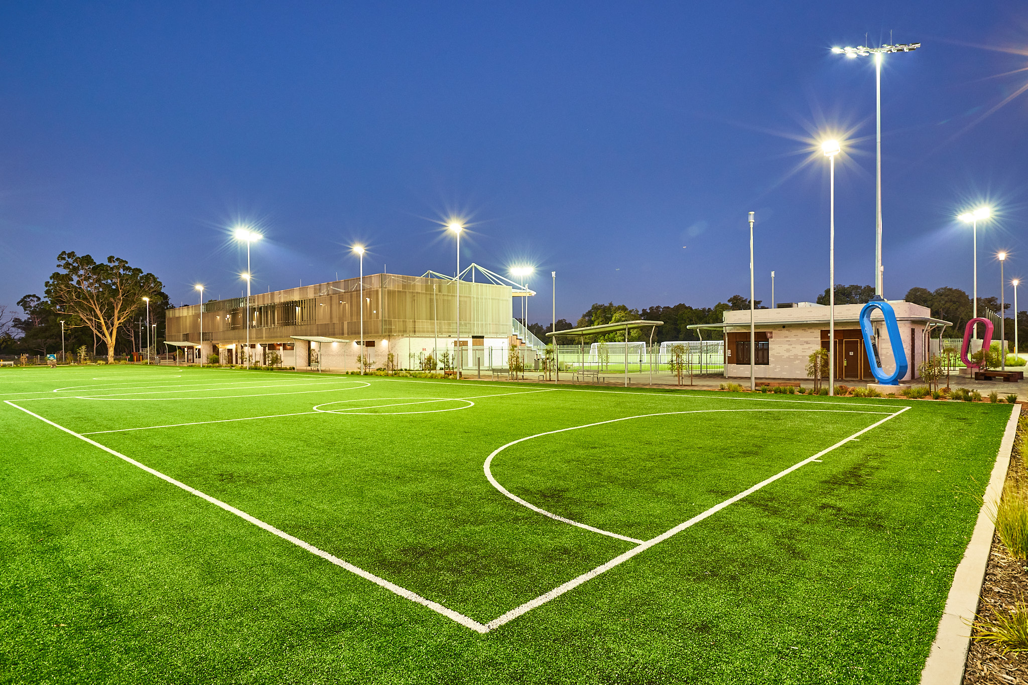 A photo of one of the three five a side pitches at the Sam Kerr Football Centre in Queens Park, Perth with the main building in the backdrop