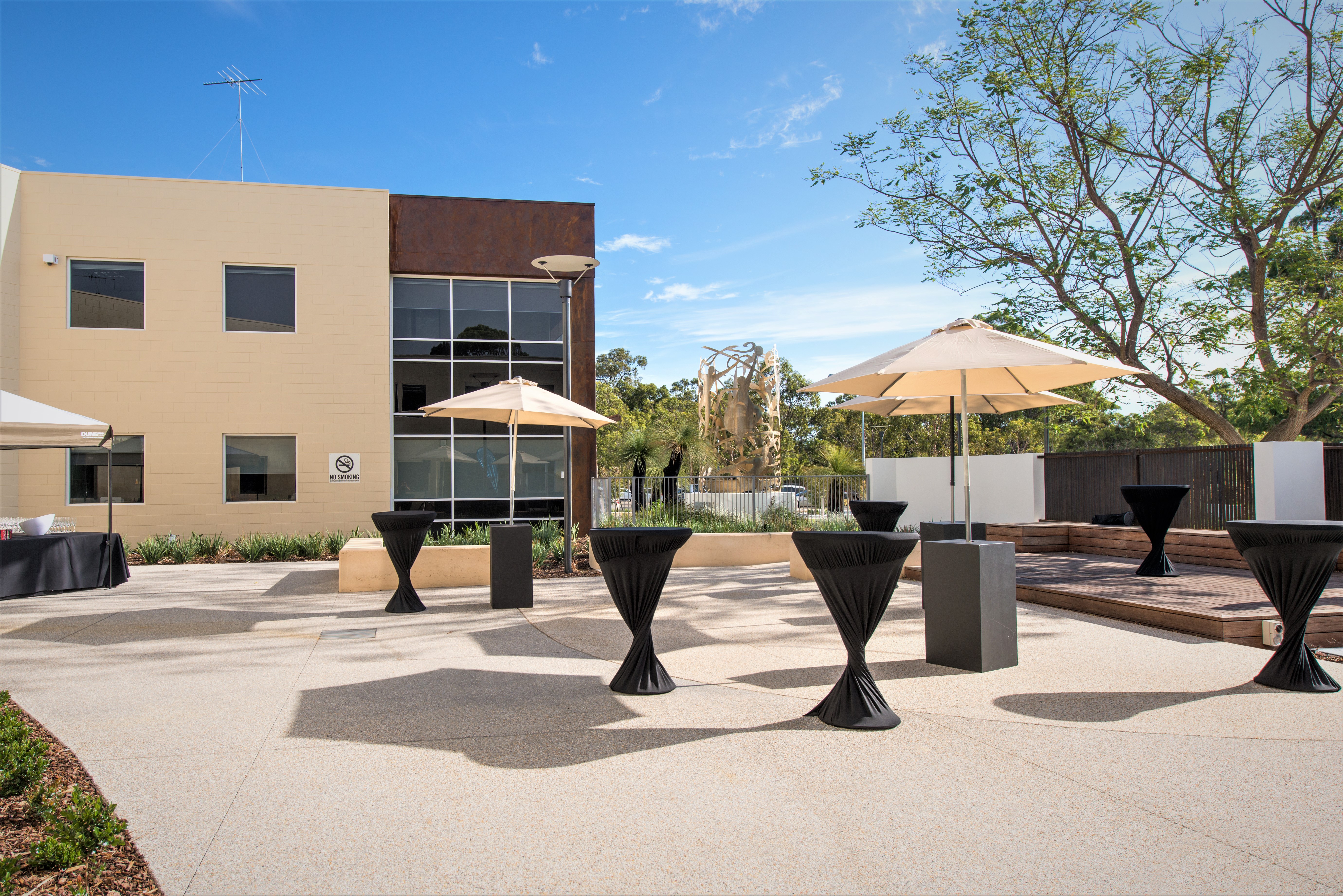 A photo of the courtyard outside of Perth HPC, including shade sails, benches and planters