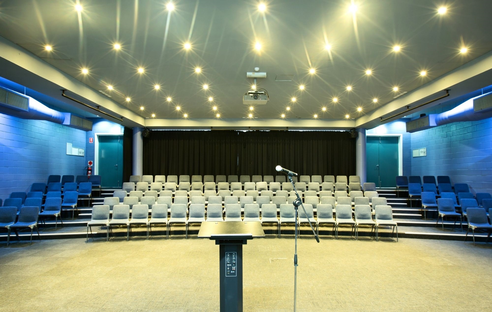 A photo of a lecturn overlooking rows of chairs in the lecture theatre at Perth HPC