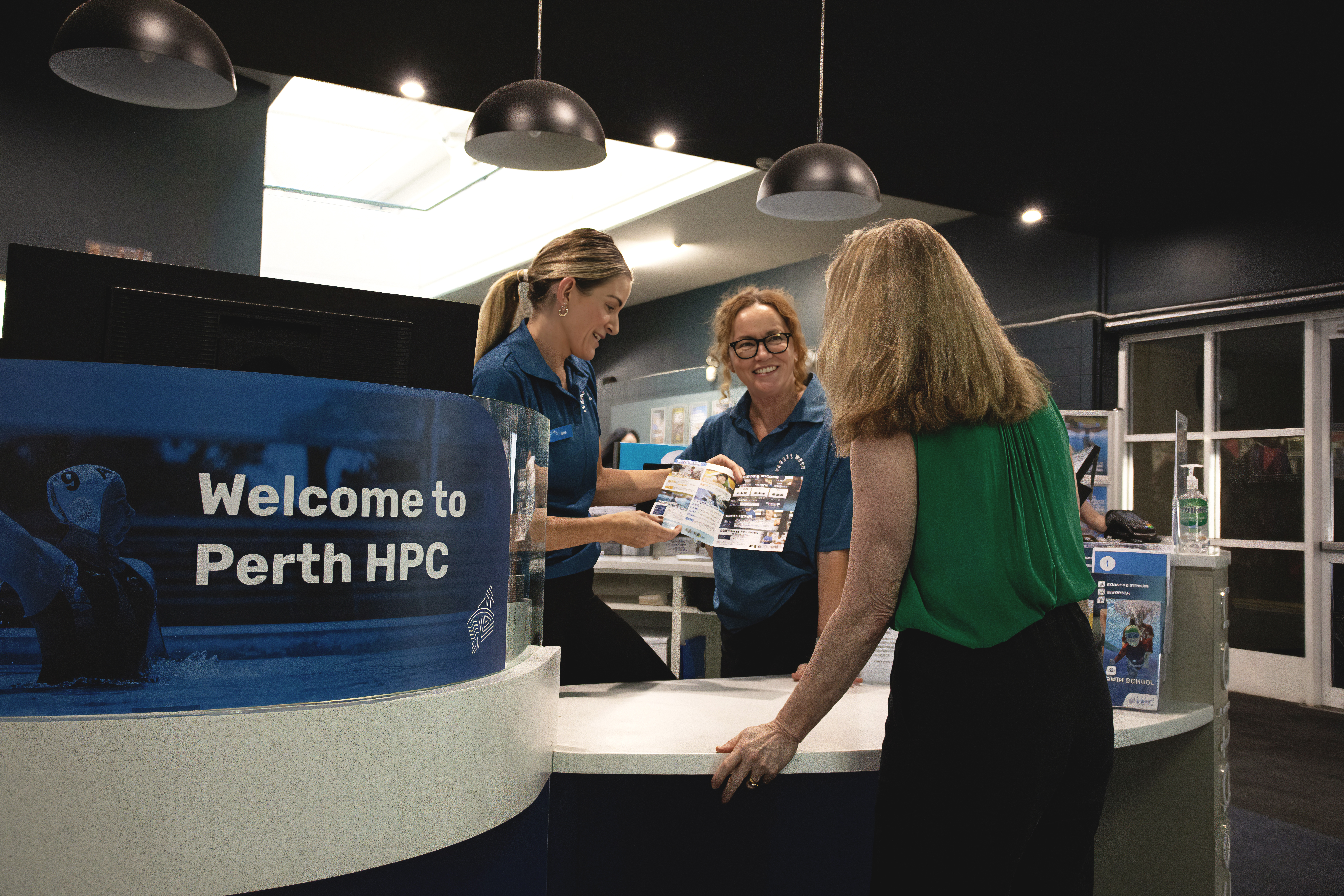 A photo of two VenuesWest reception staff assisting a customer
