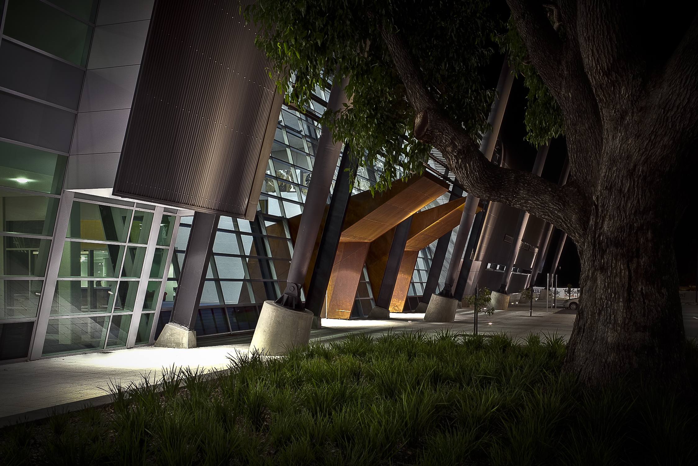 A photo taken at night time showing a side angle of the front exterior of Bendat Basketball Centre