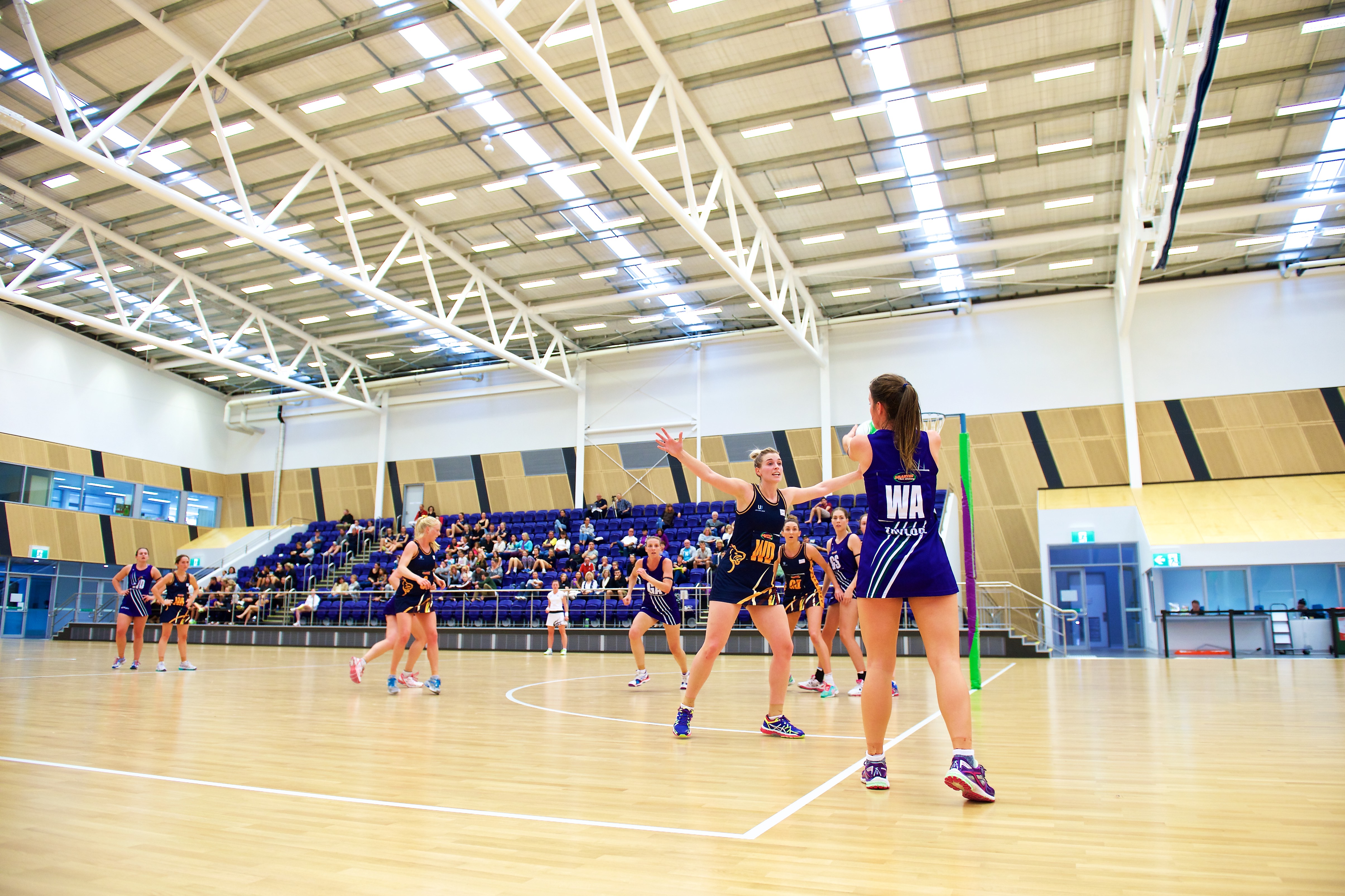 A photo of netball being played indoors at the Gold Netball Centre in Jolimont, Perth