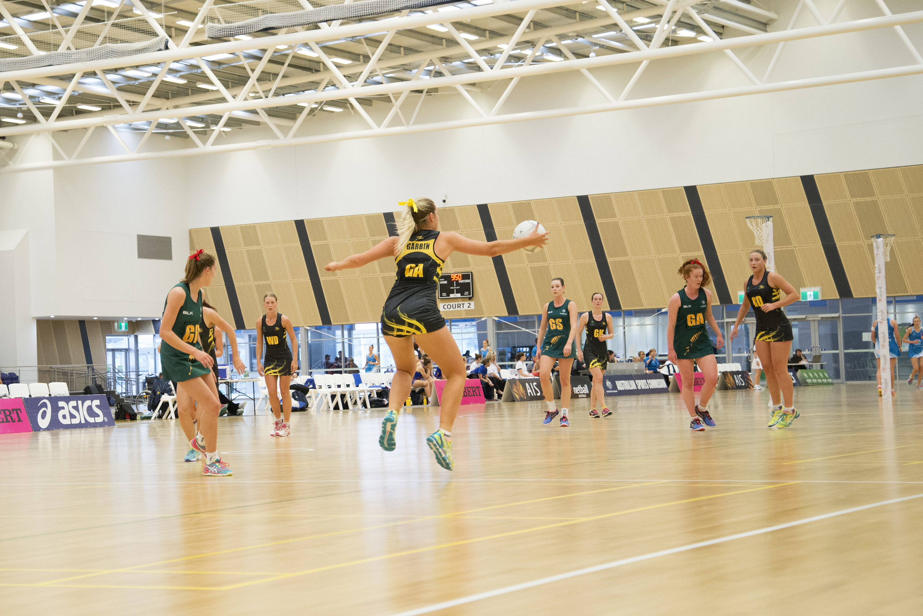 A photo of netball being played on one oof the indoor courts at the Gold Netball Centre in Jolimont, Perth