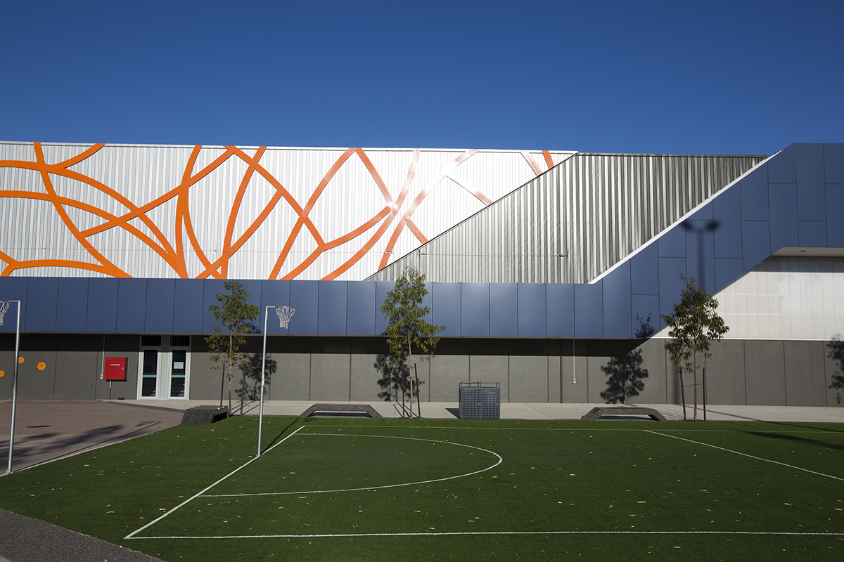 A photo of an outdoor netball court with the main building in the background at the Gold Netball Centre in Jolimont, Perth