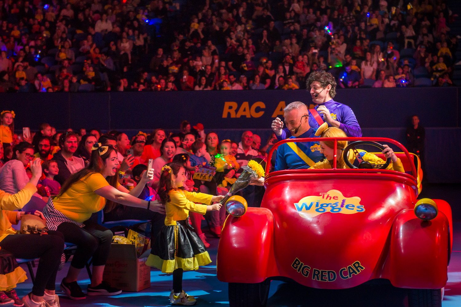 A photo of The Wiggles driving their big red car at RAC Arena in Perth
