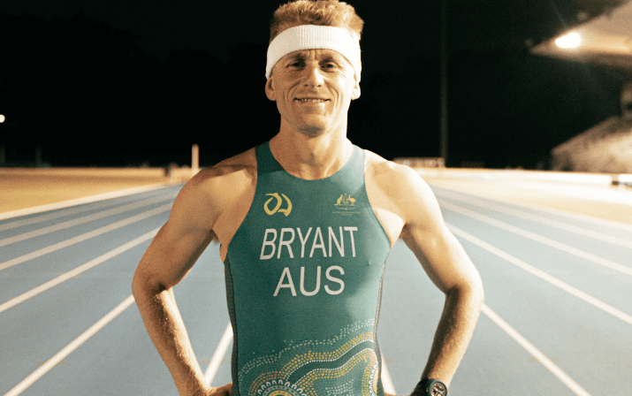 Close up photo of David Bryant wearing a headband and an Australian singlet standing on the track at the WA Athletics Stadium in Mount Claremont, Perth