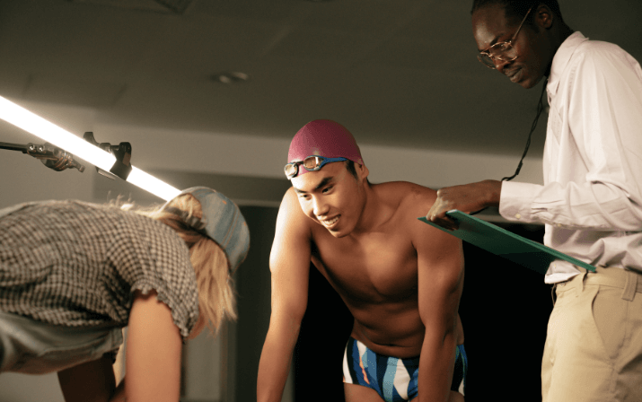 Josh Yong wearing a swimming cap and goggles being tended to by two helpers with clipboards at the WAIS High Performance Service Centre in Mount Claremont, Perth