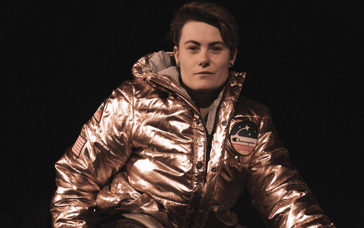 Close up photo of Robyn Laimbird posing in her racing wheelchair at the WA Athletics stadium