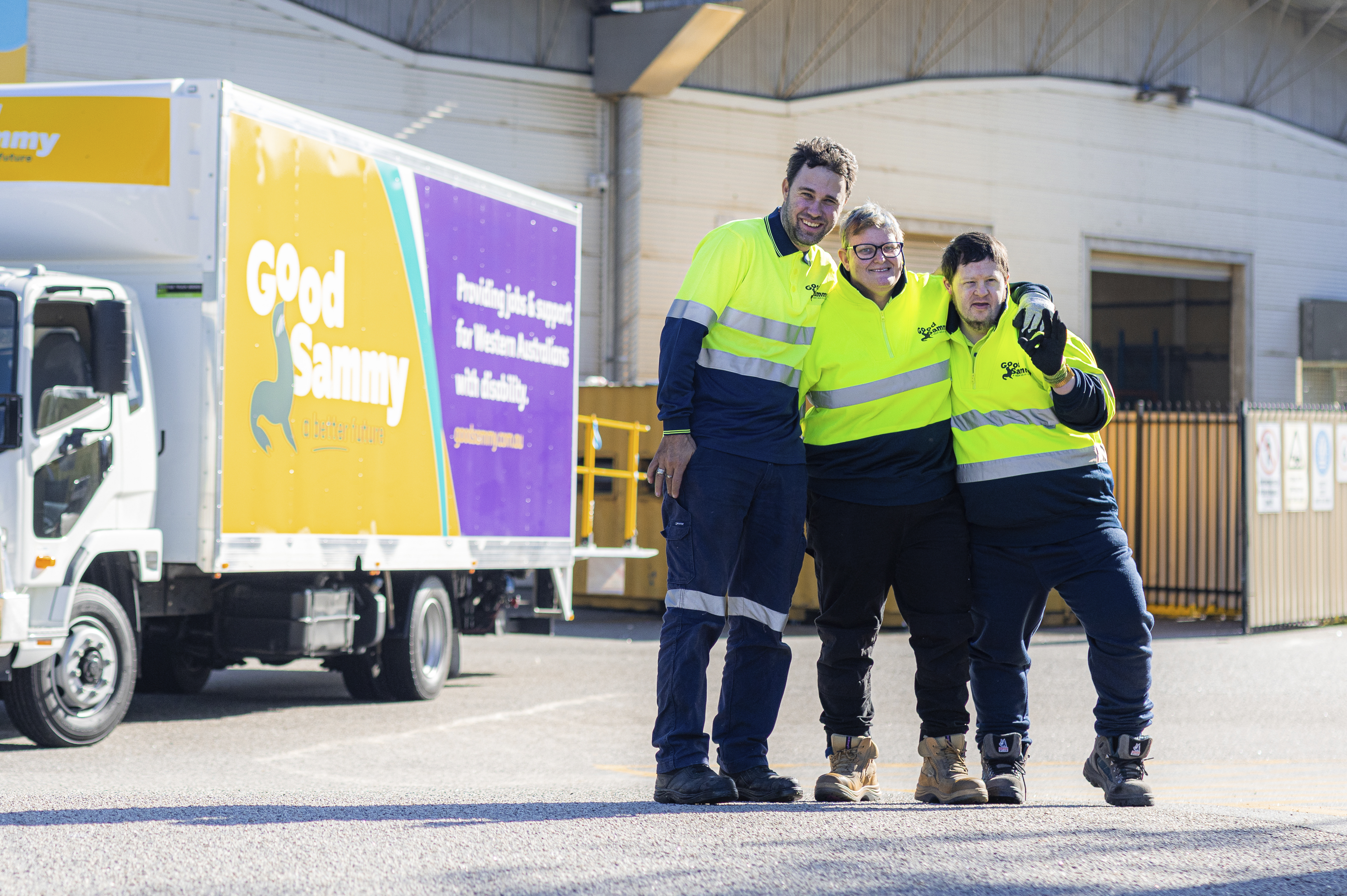 A photo of three people in high vis gear in front of a Good Sammy van