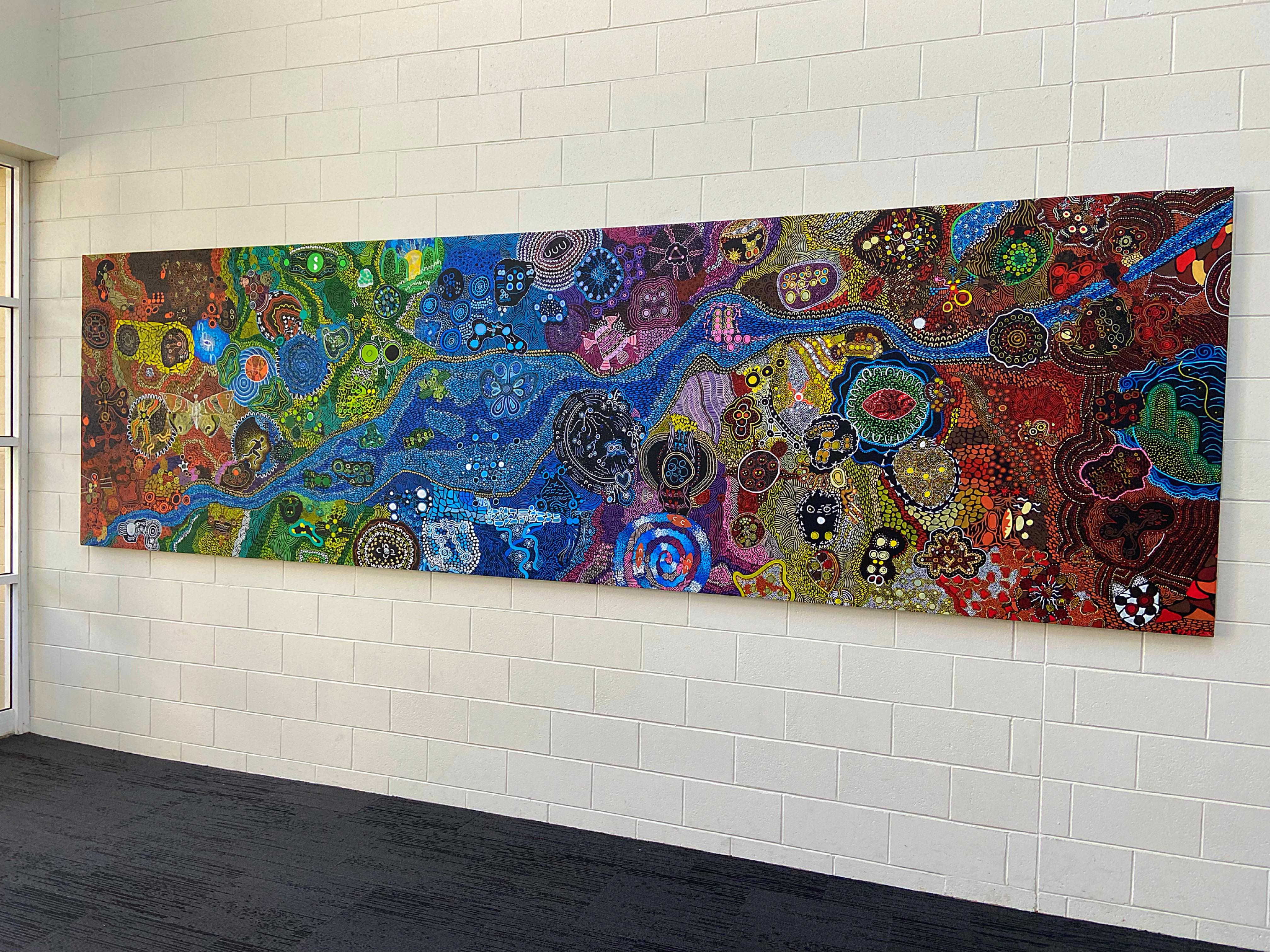 A photo of Aboriginal artwork being hung inside of HBF Stadium