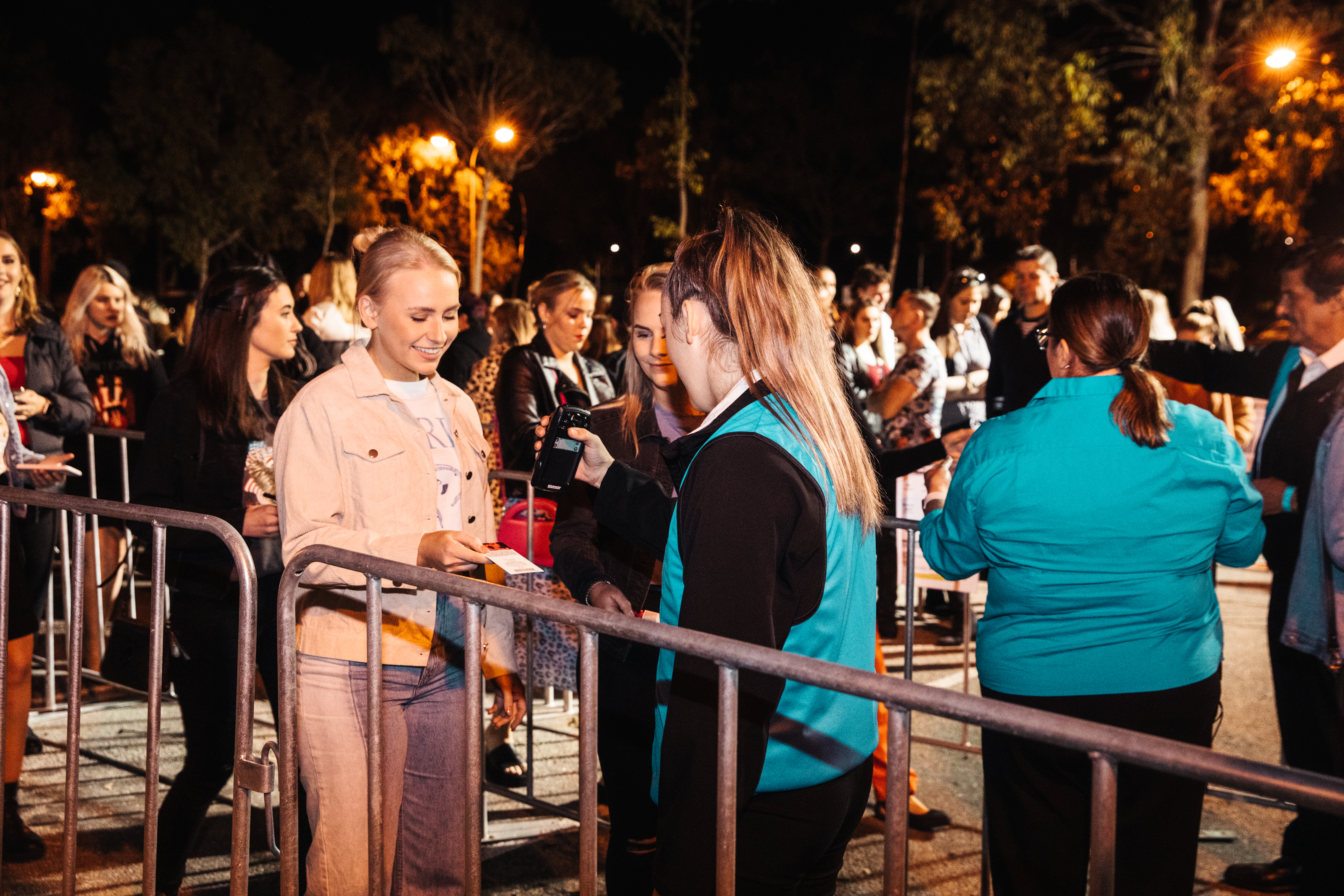 A photo of a VenuesWest staff member scanning a patron's ticket
