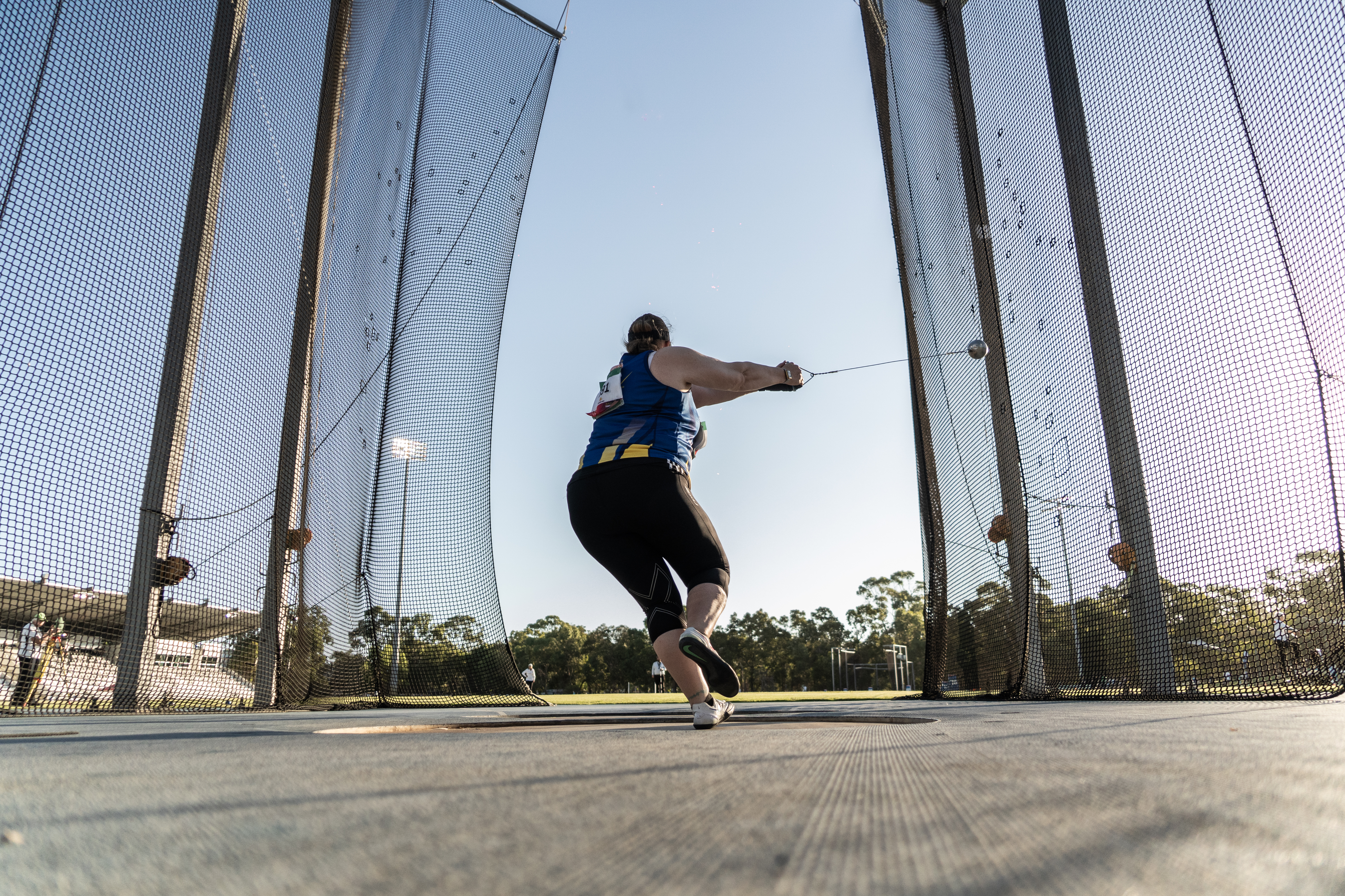 A photo of a man mid discus throw at the WA Athletics Stadium