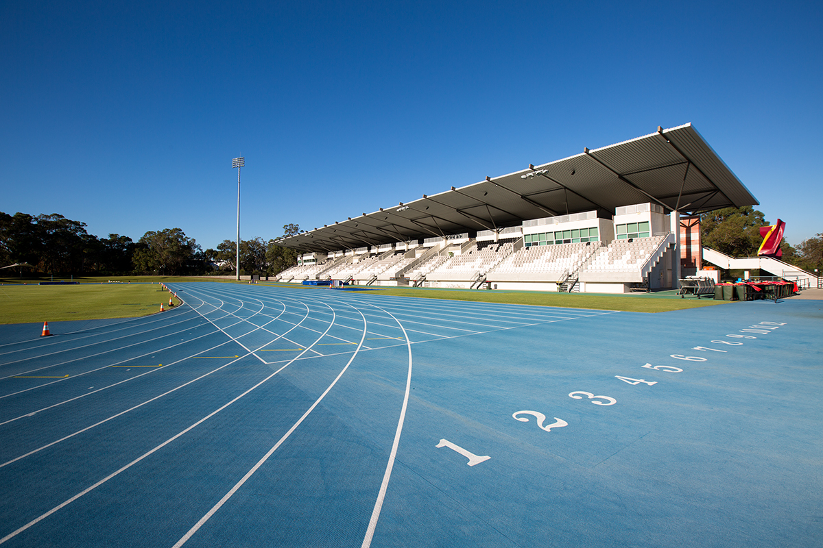 A photo of the start of the 110m sprint track straight at the WA Athletics Stadium with a seating stand in the background