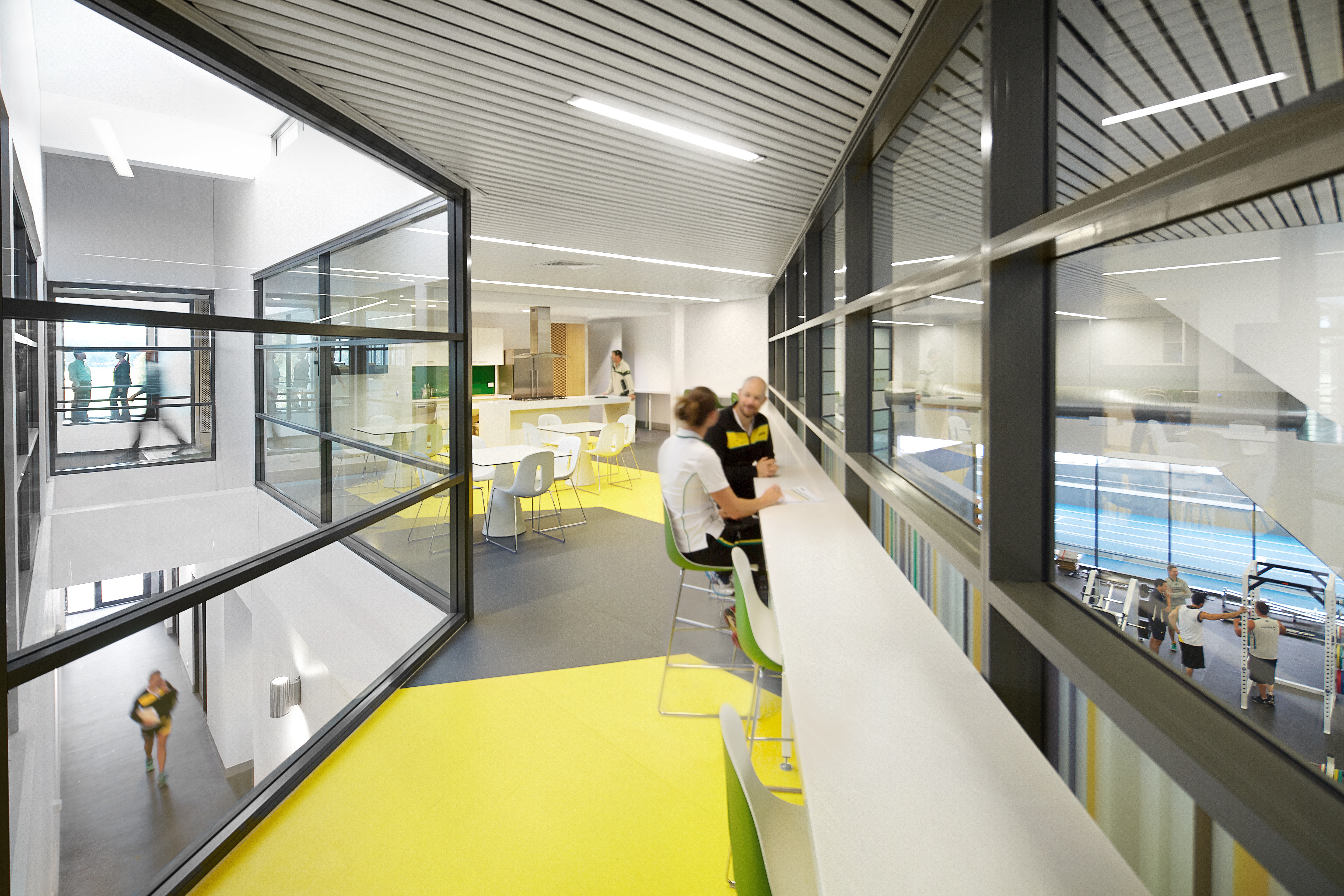 A photo of two people sitting down overlooking the gym space at the WA Institute of Sport